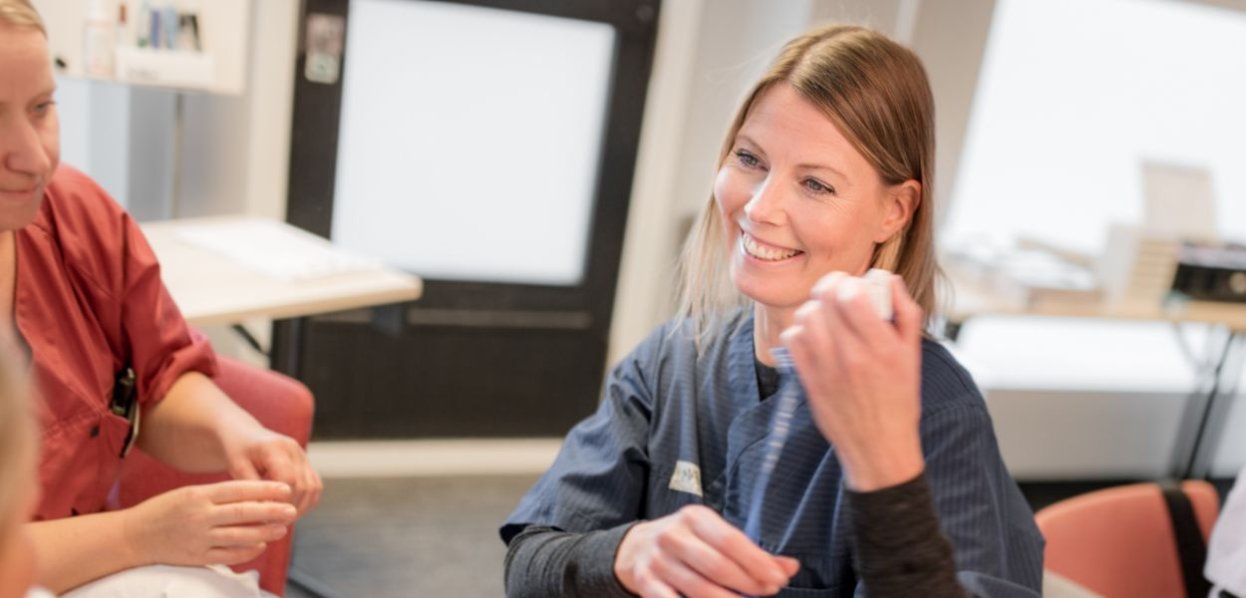 Kvinnelig student smiler til pasient