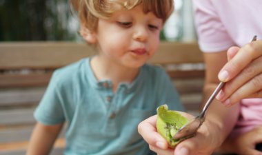 Bilde av en liten gutt som spiser kiwi