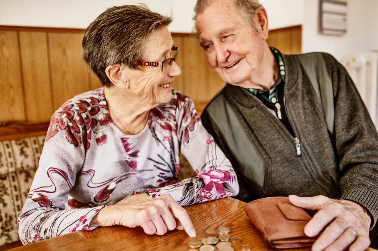 Eldre par sitter å smiler 
